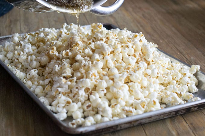 Pour the candy mixture over the popcorn. I advise that you wear oven mitts just in case there's a spill and any part of your brain thinks it's a good idea to touch that stuff. It's hot. It will stick to you. It will not be fun.