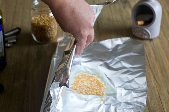Fold the foil over the popcorn and oil.