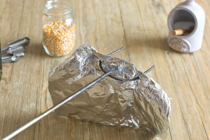 Poke the campfire fork through that thick band of foil you created at the top.