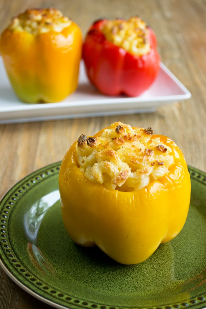 Mac and cheese yellow stuffed pepper on a green plate.