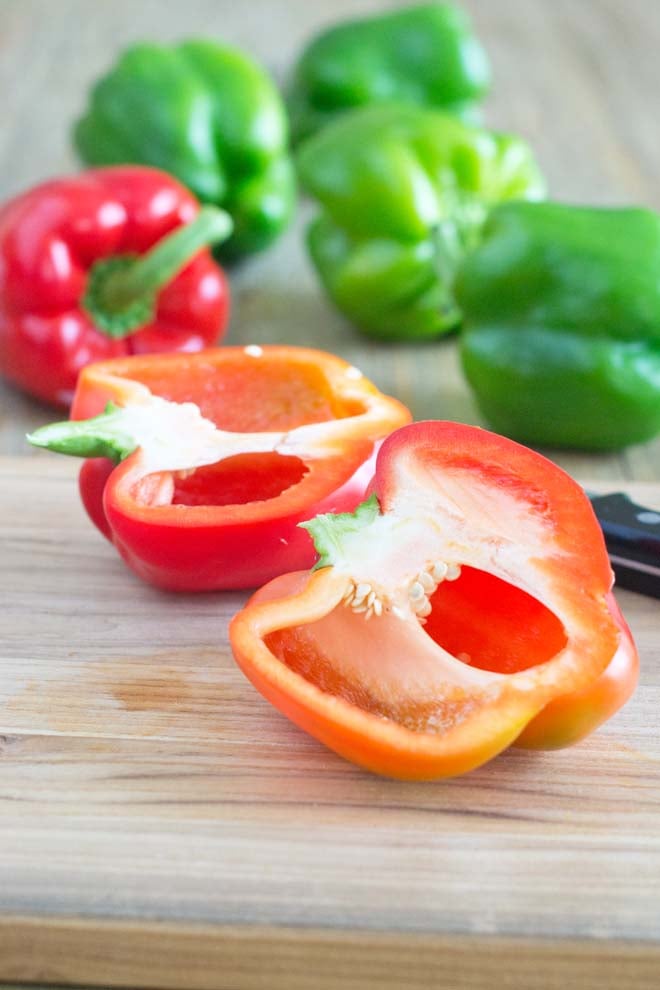 A red bell pepper cut in half vertically yielding two bell pepper boats.