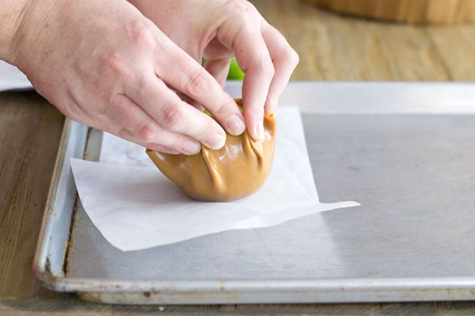 Smoothing the caramel disc around the apple