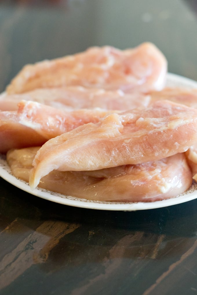 Frozen chicken breasts on a white plate.