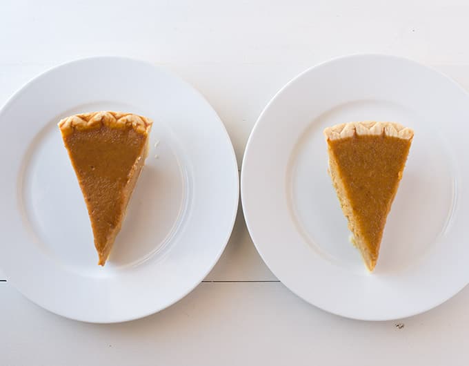 Two white plates side by side with a slice of pie on each.
