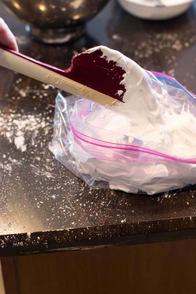 Place in a bag for piping Spatula putting marshmallow mixture into ziptop bag.