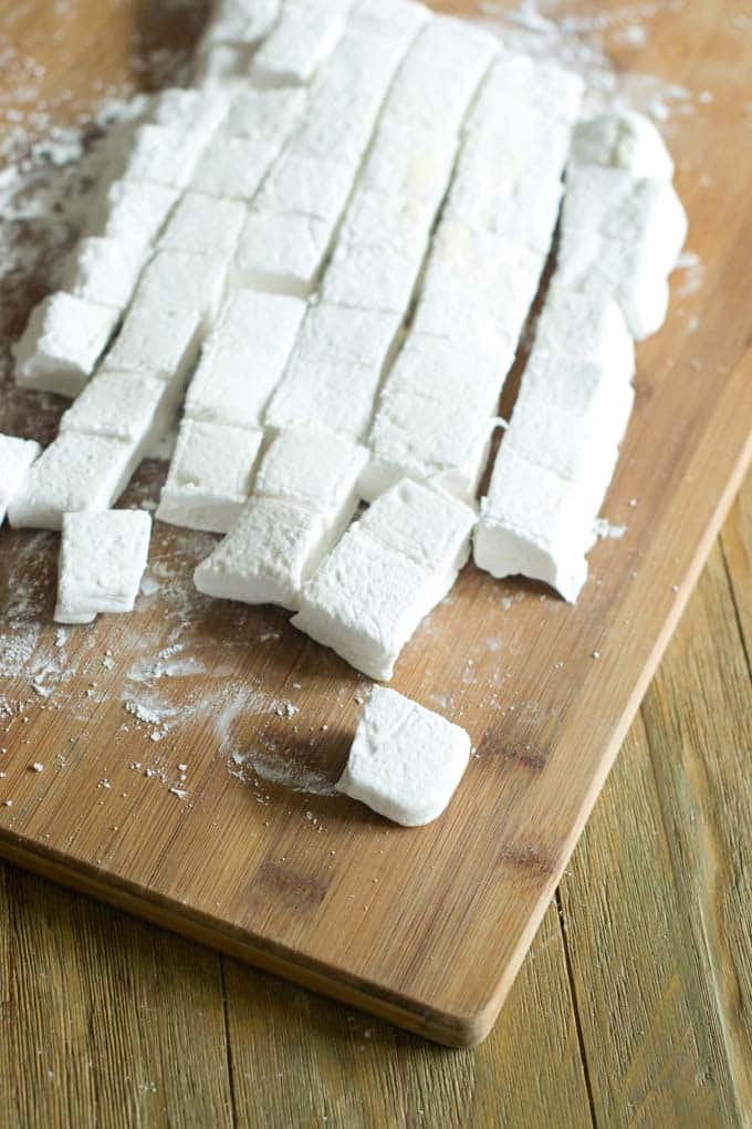 Cutting board full of large marshmallows.