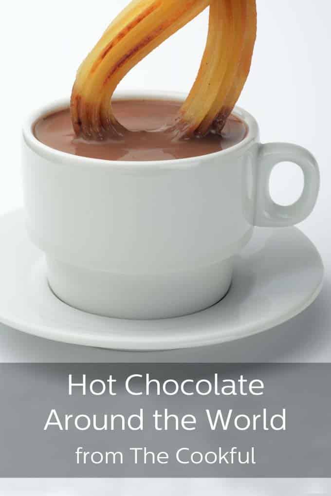 White cup and saucer, with the cup filled with thick hot chocolate and a golden churro being dipped into the hot chocolate. The text below the picture read, "Hot Chocolate Around The World from TheCookful".