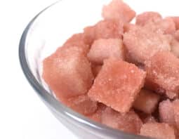 Pinkish sugar cubes in a glass bowl.