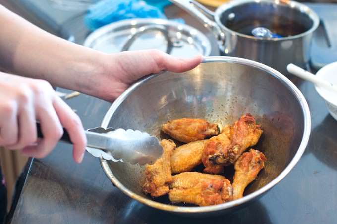 Toss chicken wings with sauce.