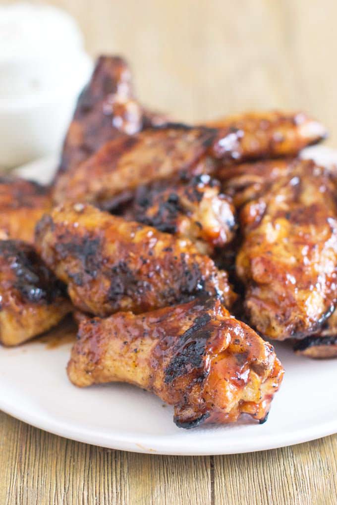 Plate of grilled chicken wings with sauce.