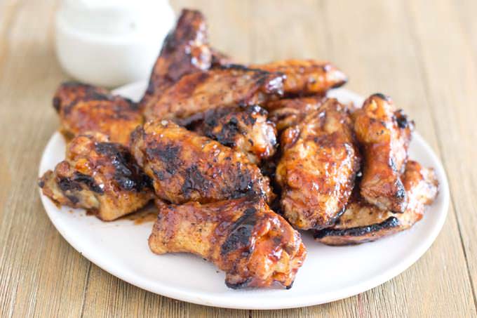 Grilled chicken wings on a white plate.