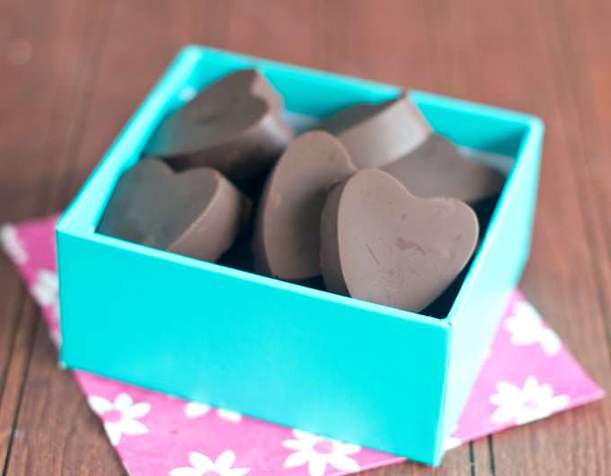 Heart shaped molded truffles in a blue box.