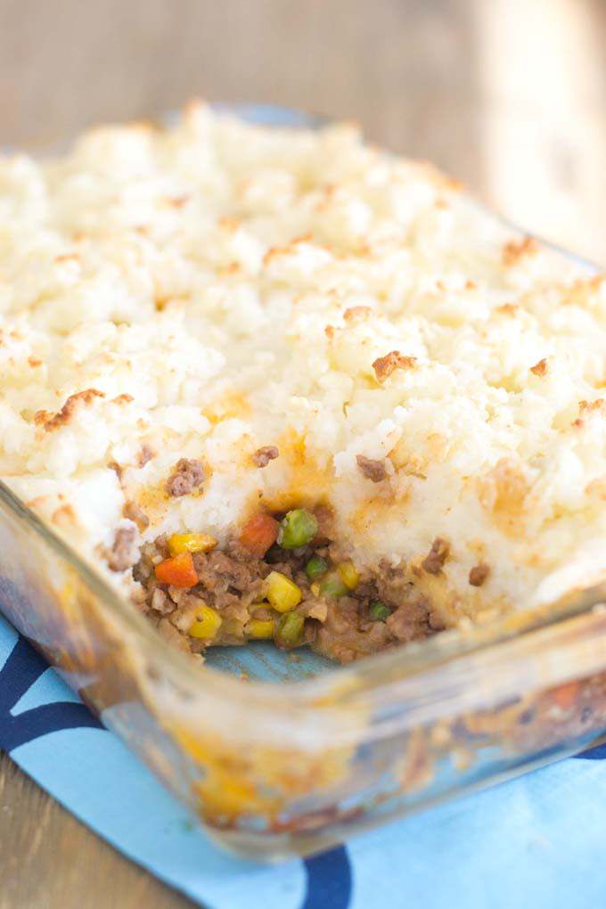 Beef shepherd's pie in glass dish with scoop taken out so you can see the filling.