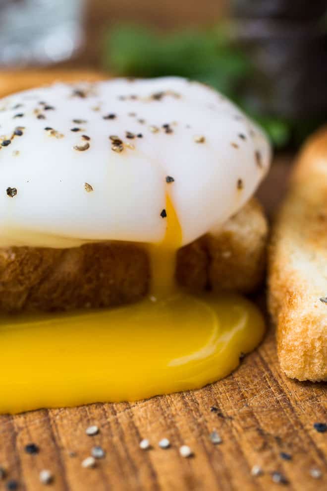 Poached egg on toast with yolk running out.