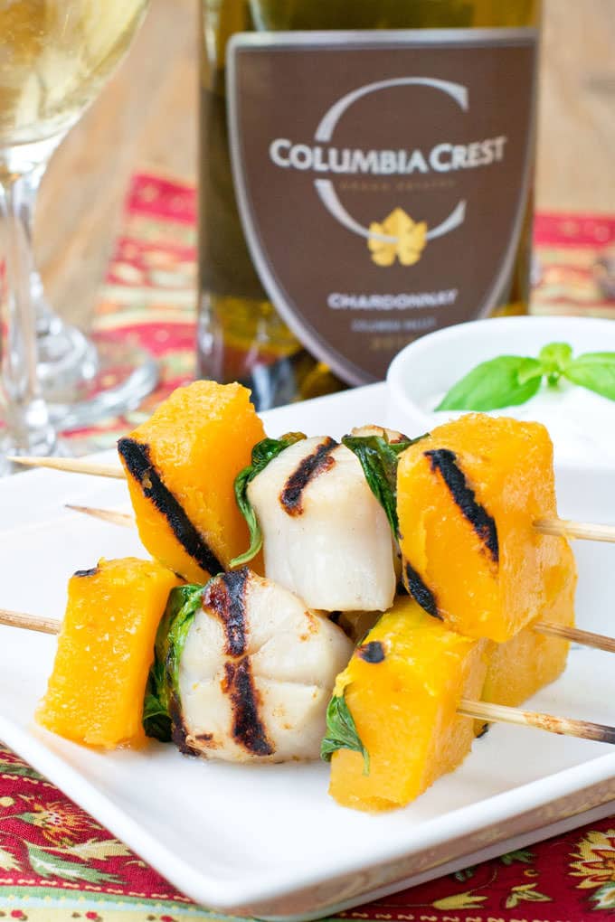 Grilled Scallops, Butternut Squash and Basil on wooden Skewers on a white rectangular plate.