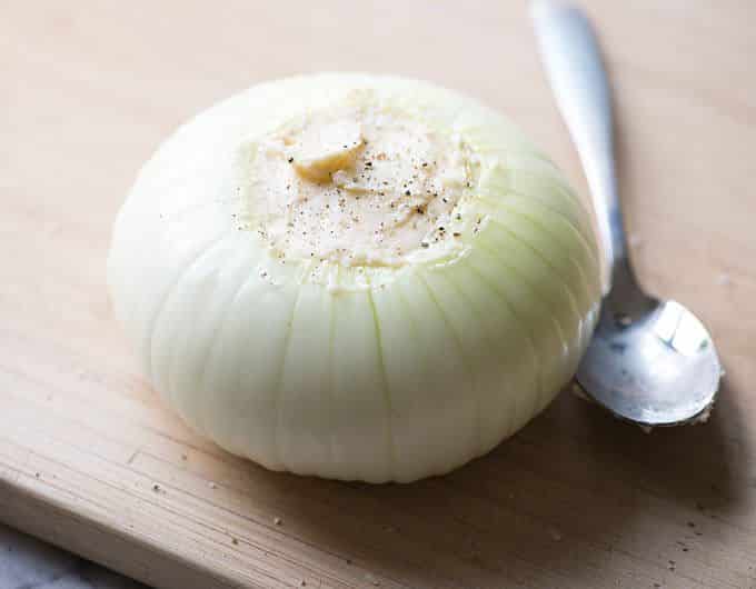 Vidalia onion filled with butter on a cutting board.