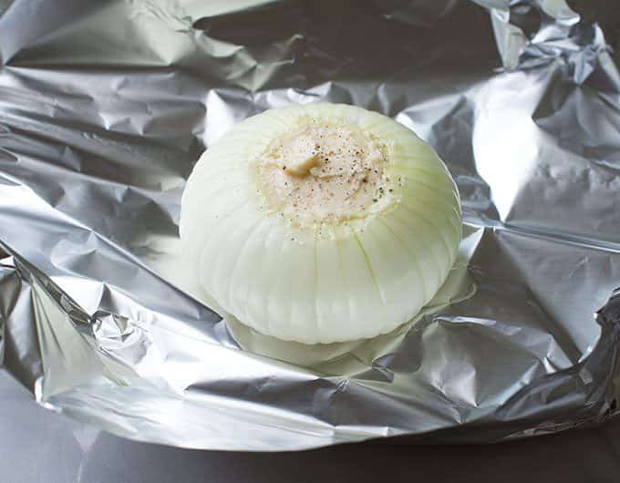 Vidalia Onions filled with butter on a sheet of foil.