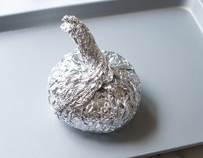 Vidalia covered with foil on a baking pan.