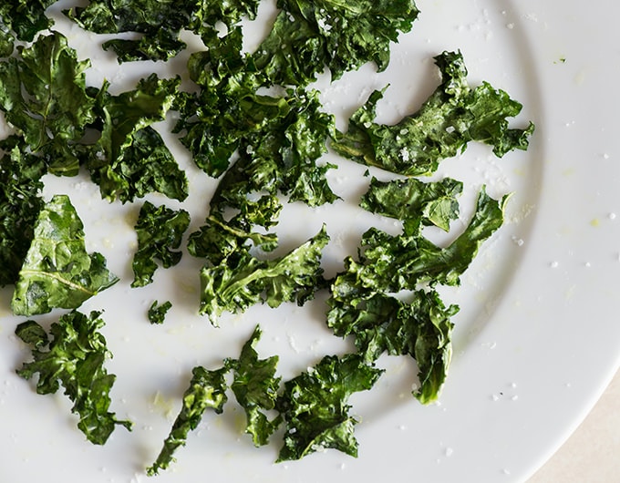 Kale Chips with salt on white plate