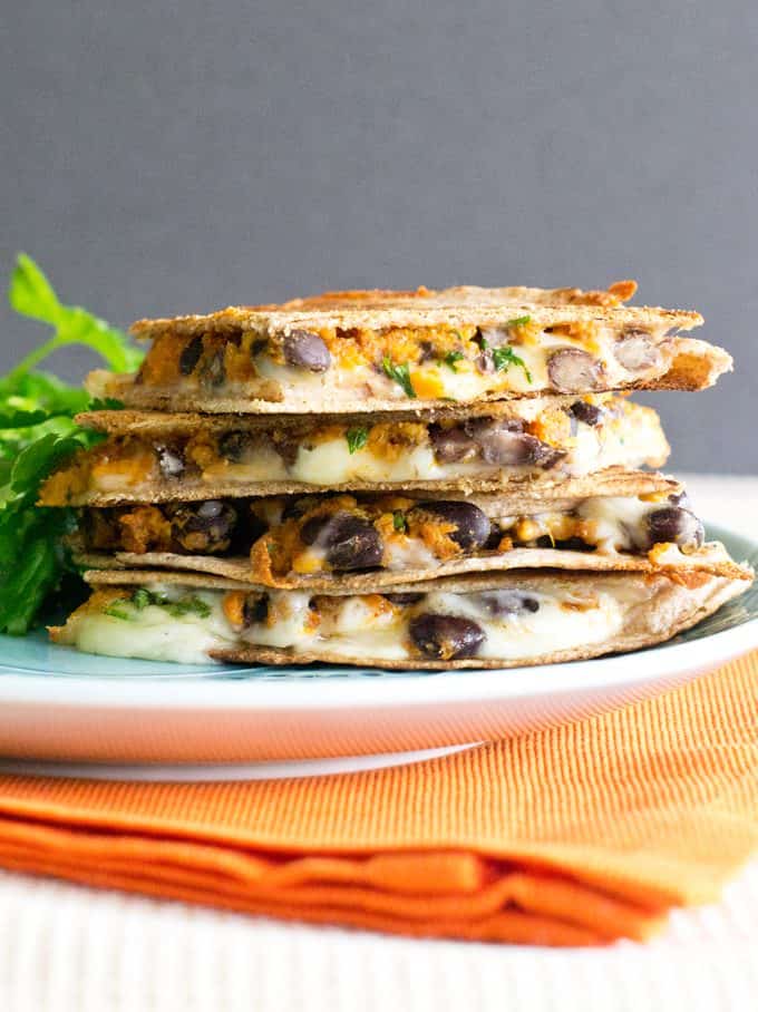 Sweet Potato and black bean Quesadillas stacked on a plate.
