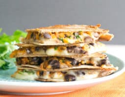 Sweet Potato and black bean Quesadillas stacked on a plate.