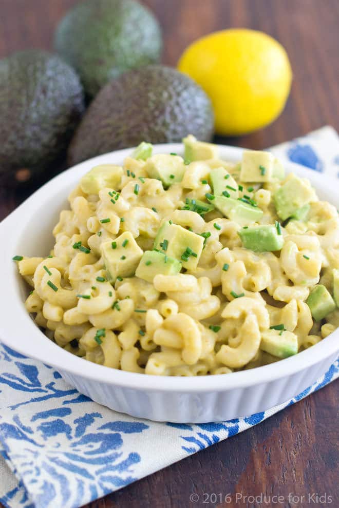 Bowl of Macaroni and Cheese with pieces of cubed avocados and diced herbs.