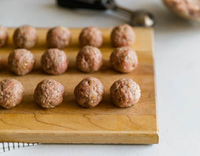 Uncooked meatballs on cutting board
