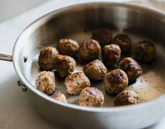 Cooked meatballs in pan.