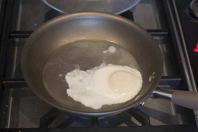 Let it cook until the steam has cooked the layer of egg whites that is over the yolk.