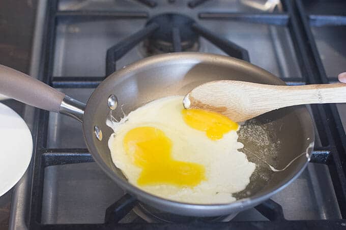 Egg yolks being broken and mixed in.