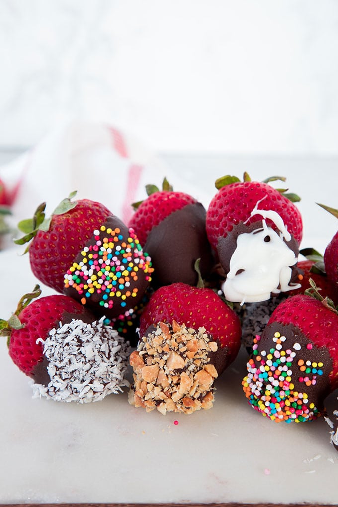Chocolate covered strawberries with various toppings.