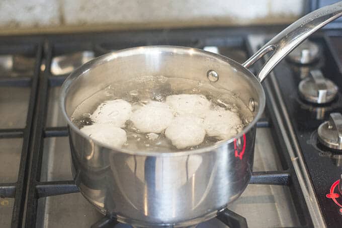 Saucepan with boiling water and eggs on the stove.