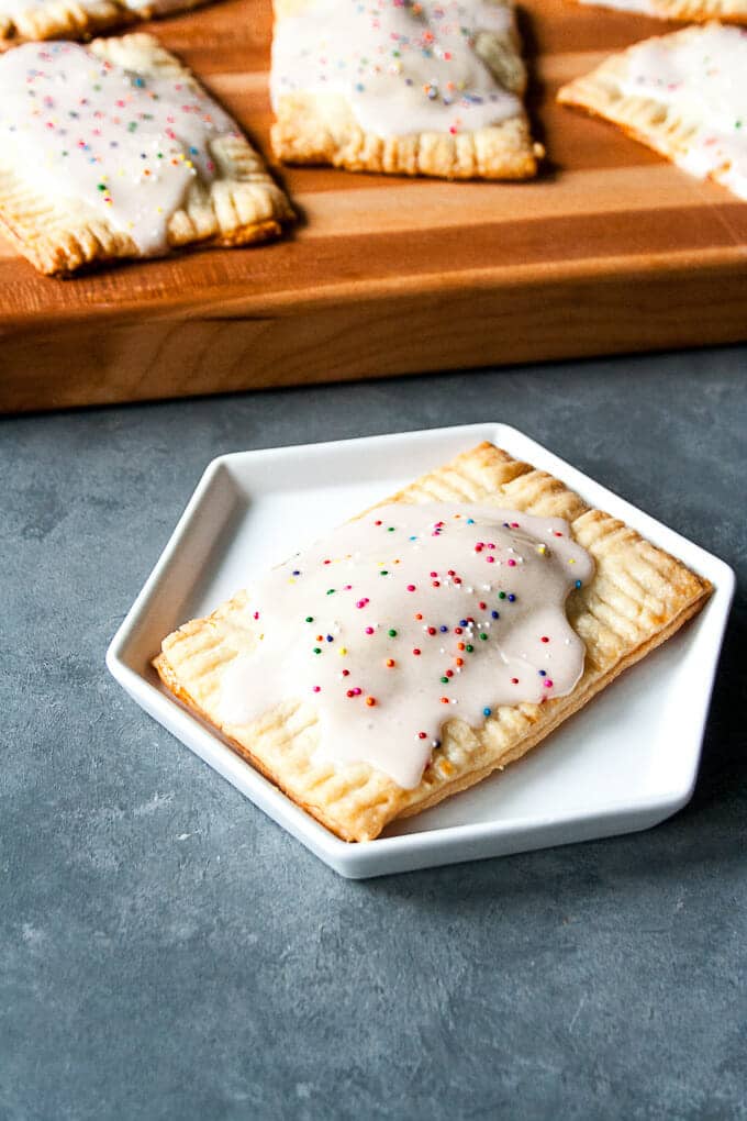 Homemade Strawberry Pop Tart on a white plate with more in the background.