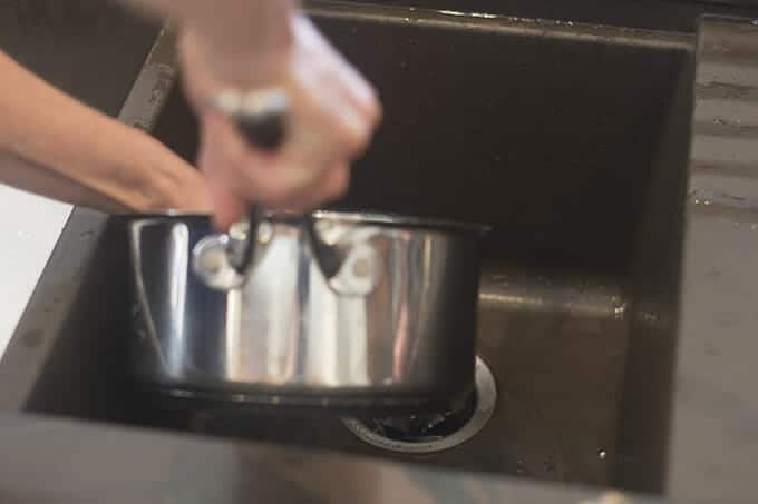 Water from pot being drained off into the sink.