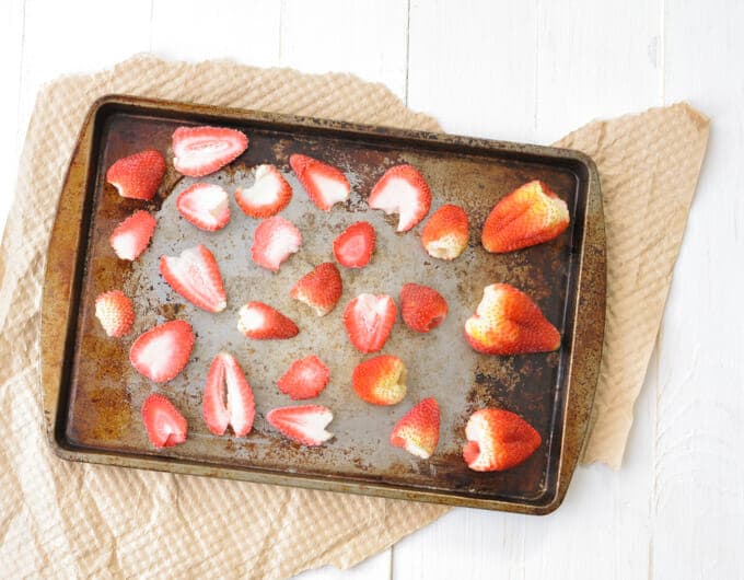 Frozen strawberries on a baking sheet.