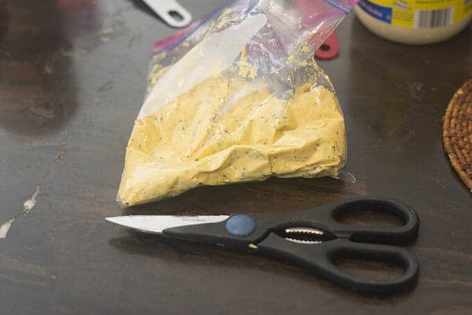 Mashed egg yolk filling in a ziptop bag with a pair of scissors.