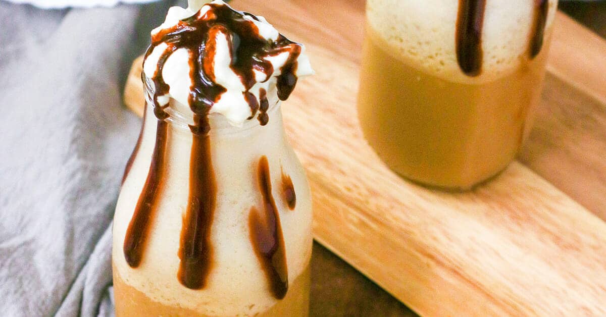 Iced coffee cocktail or frappe with ice cubes and cream in