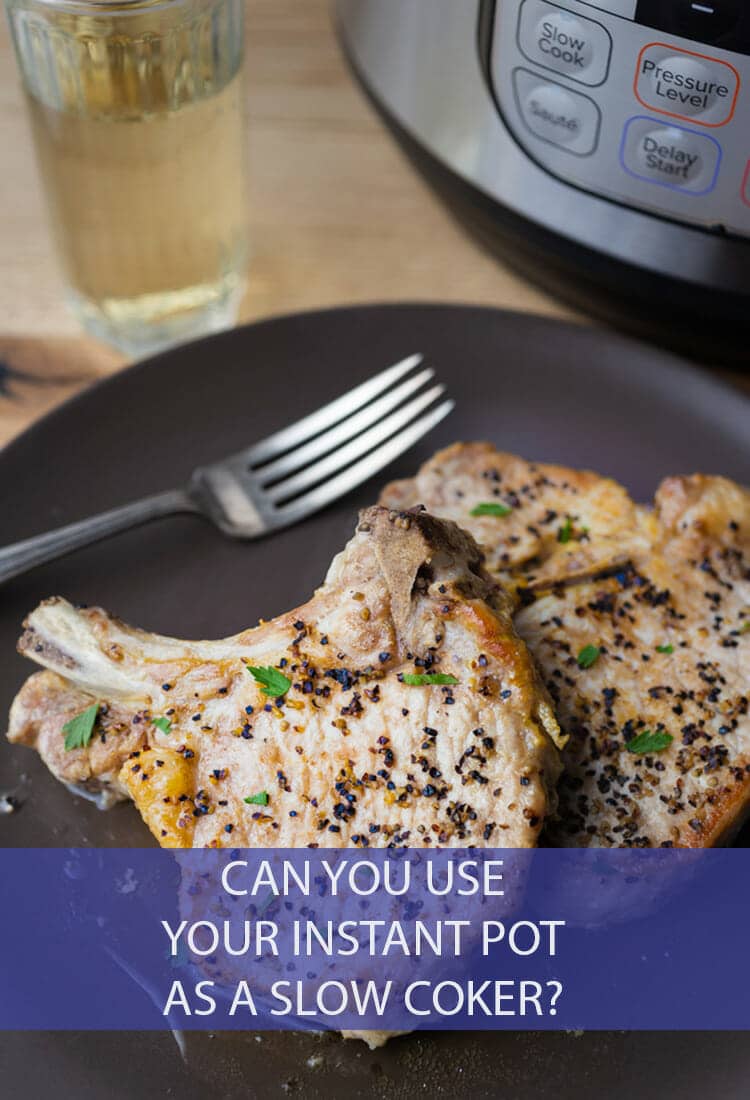 2 seasoned, cooked to golden bone-in pork chops on a round black plate with a fork on it. In the background you can see an Instant Pot and glass of white wine.