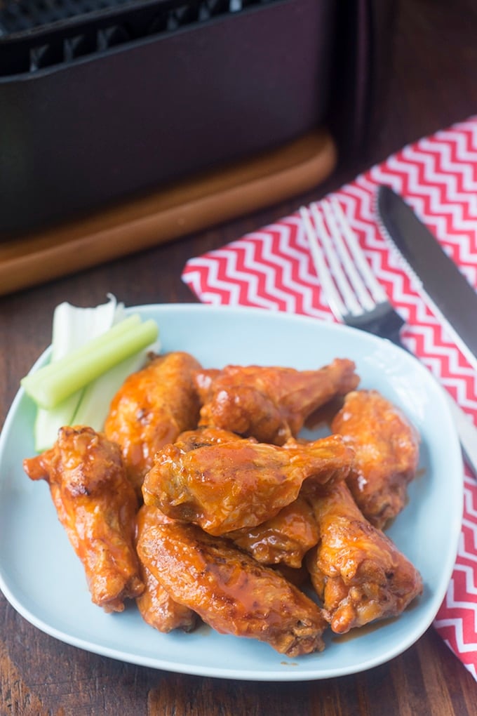 Buffalo wings and celery sticks on a plate.