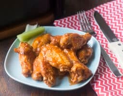 Buffalo wings and celery sticks on a plate.