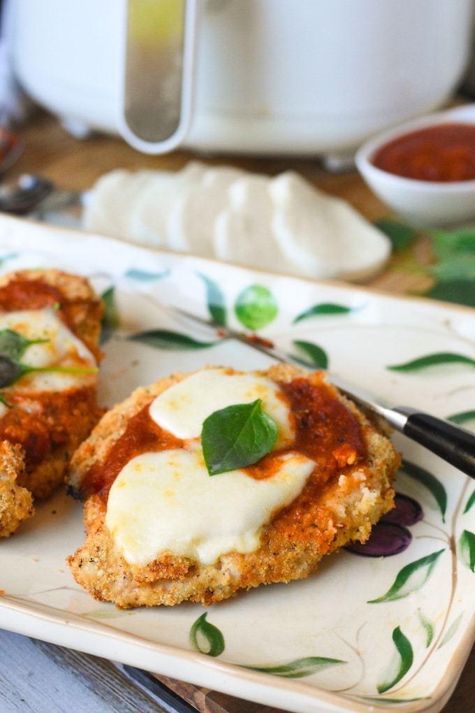 Chicken Parmesan in the air fryer is amazing. Nice and crispy breaded chicken topped with sauce and cheese. It tastes just like the oven baked classic but you don't have to heat up the oven or wait as long for it to cook.