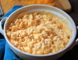 Serving dish of creamiest mac and cheese with grated cheddar in background.