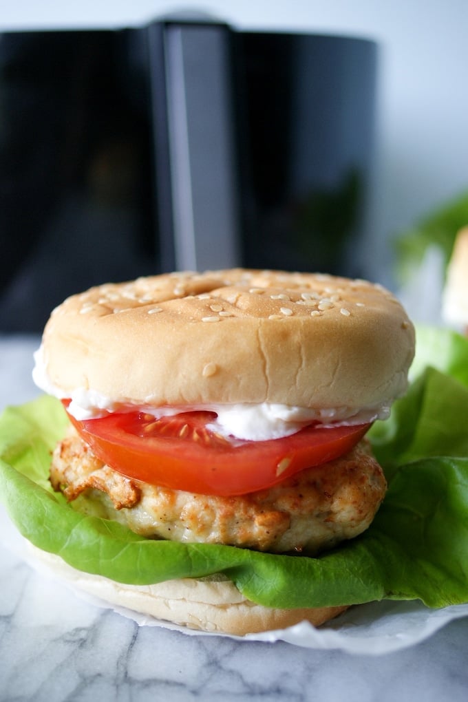 Chicken burger with lettuce, tomato, and mayo.