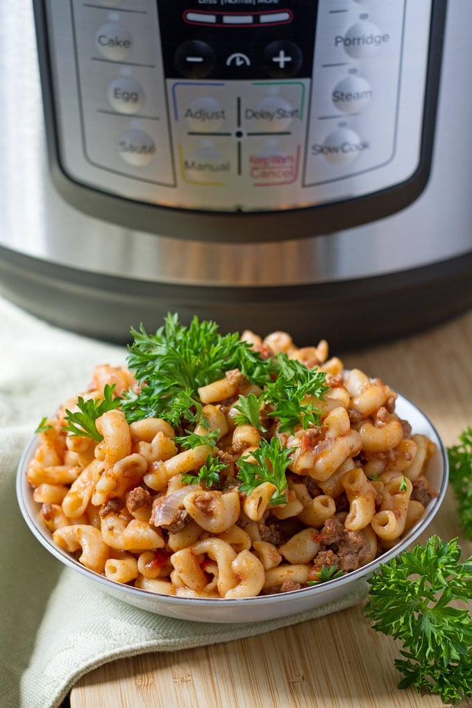 Instant Pot Goulash Bowl of goulash in front of Instant Pot
