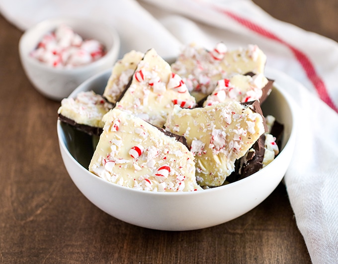 Pieces of white chocolate and peppermint bark in a white bowl.