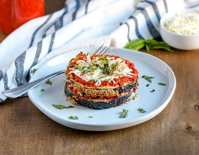 White plate with stack of eggplant parmesan.