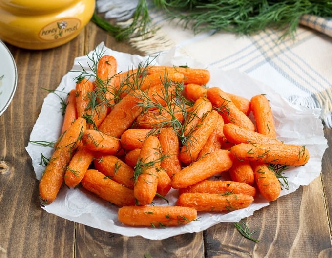 Baby carrots cooked with glaze and topped with herbs.