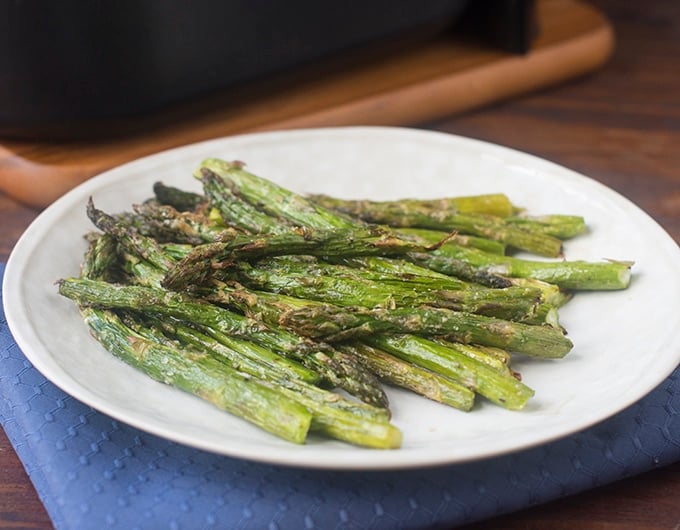 Cooked Air Fryer Asparagus on a white plate.