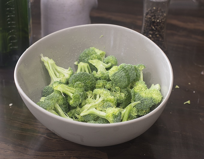 Raw broccoli florets in bowl.