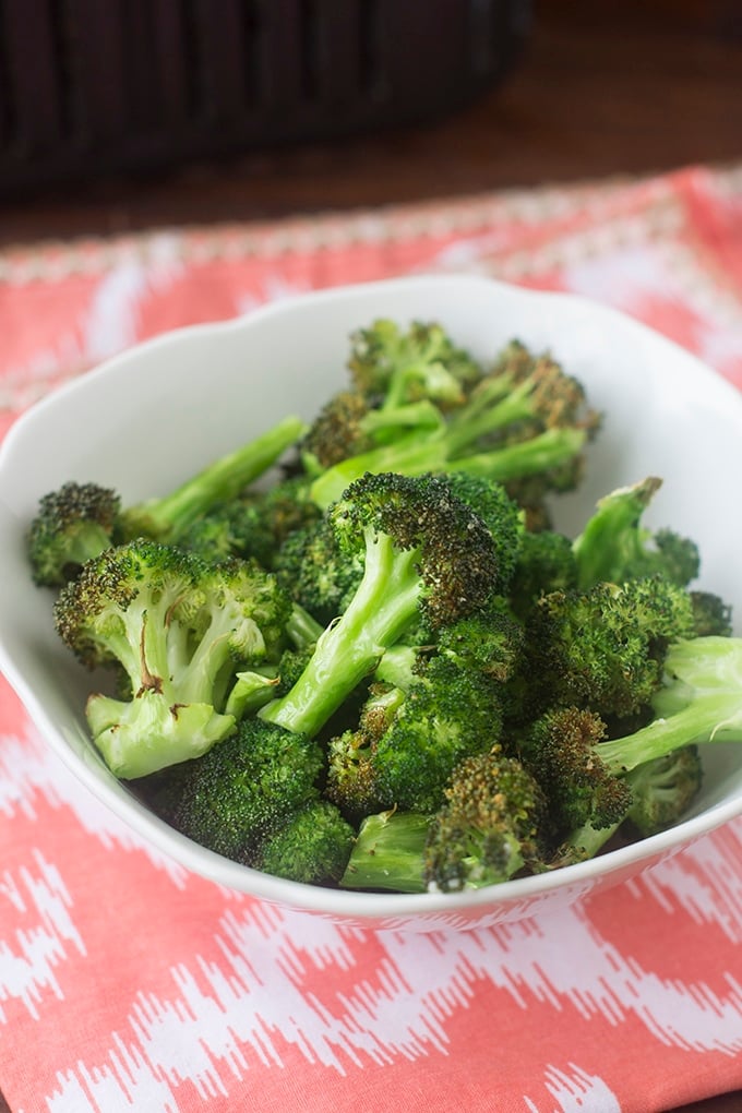 White bowl of cooked broccoli florets.